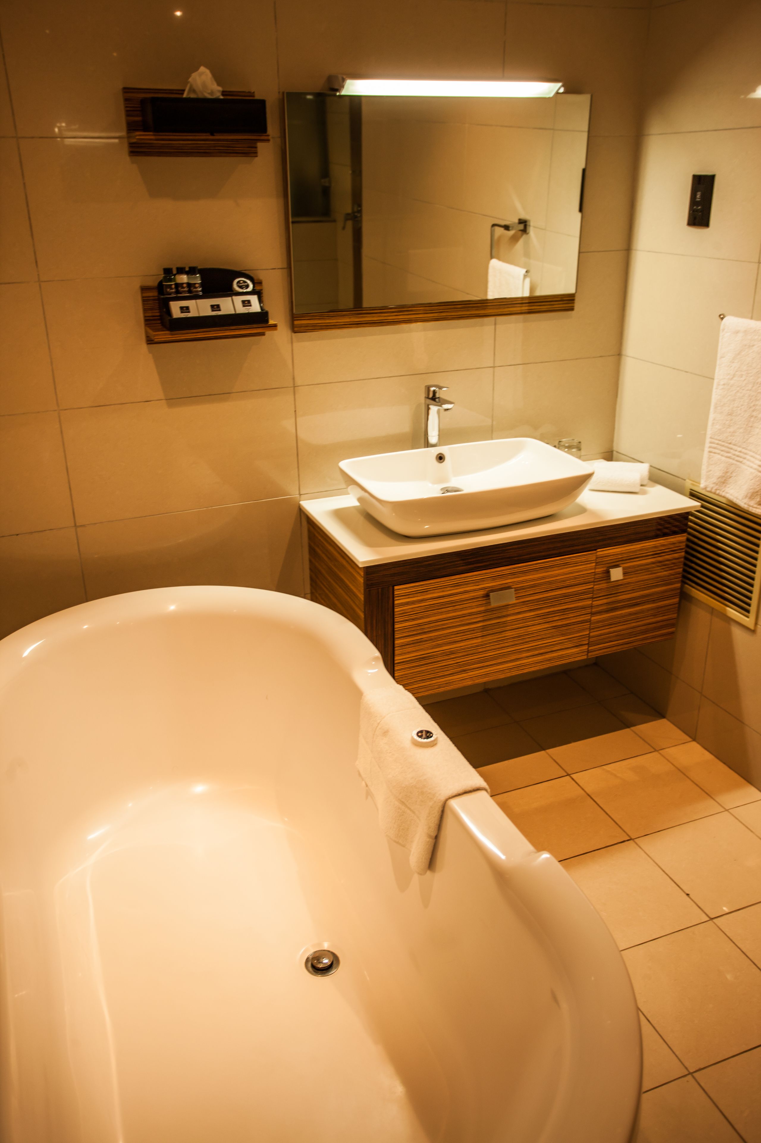 A bathroom with a freestanding bathtub, a sink, and a mirror.