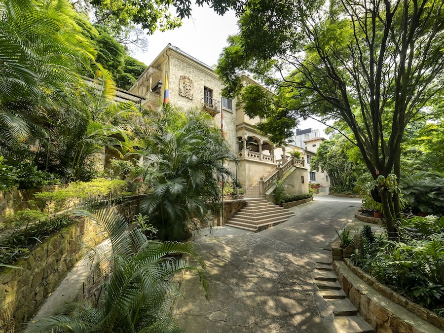 Un sendero de piedra que conduce a un edificio con balcón y escalera.