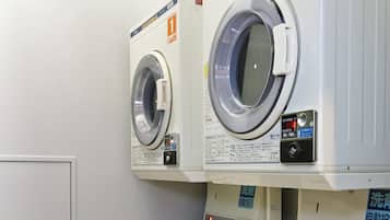 Une buanderie équipée de quatre machines à laver, chacune étant numérotée de 1 à 4.