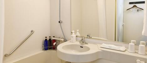 A modern bathroom with a bathtub, a sink, a toilet, and a mirror.