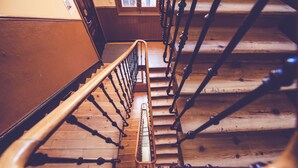 A wooden staircase with a handrail and metal balusters. - Hostal Prado (Madrid)