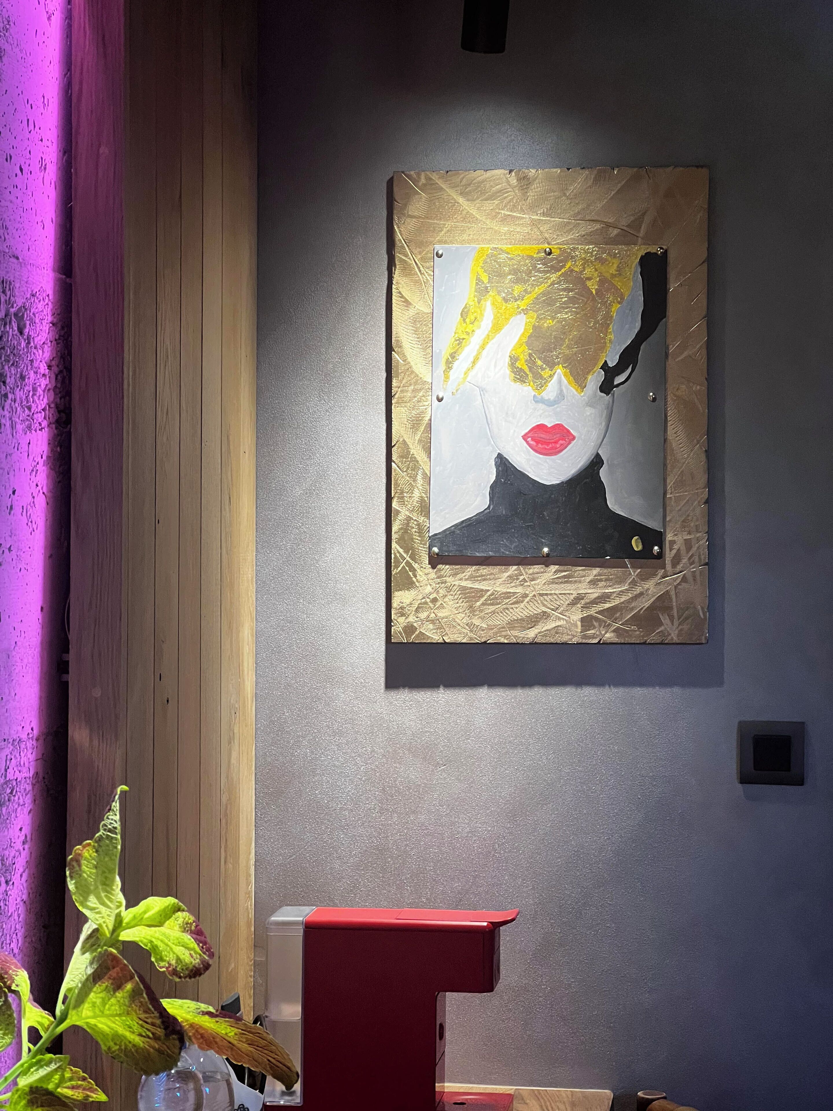 A room with a wooden panel wall, a red accent piece, and a framed artwork on the wall.
