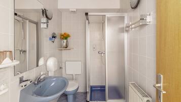 Un baño moderno con lavamanos, inodoro y ducha.