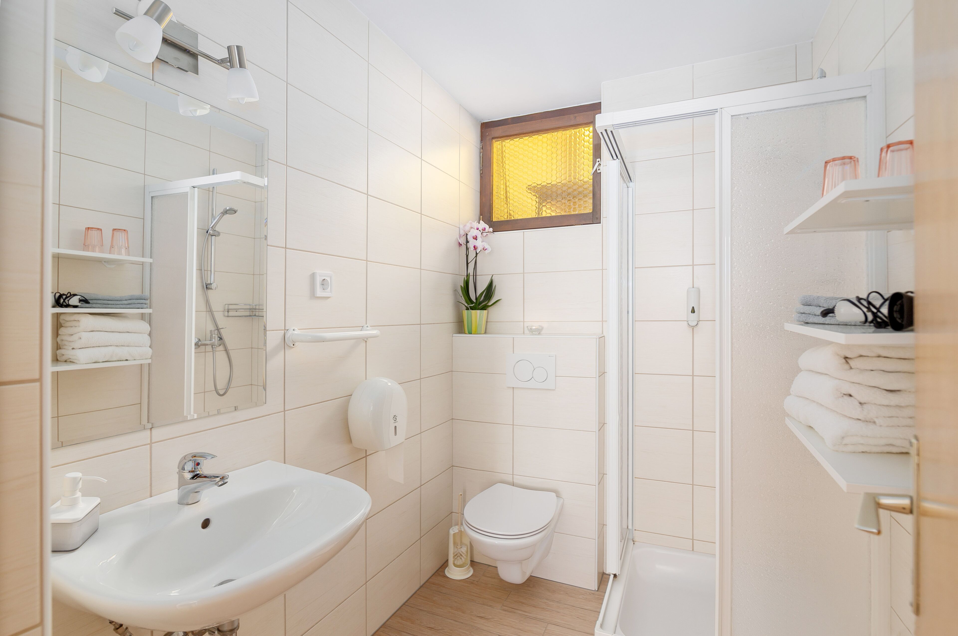 A modern bathroom with a sink, toilet, and shower.
