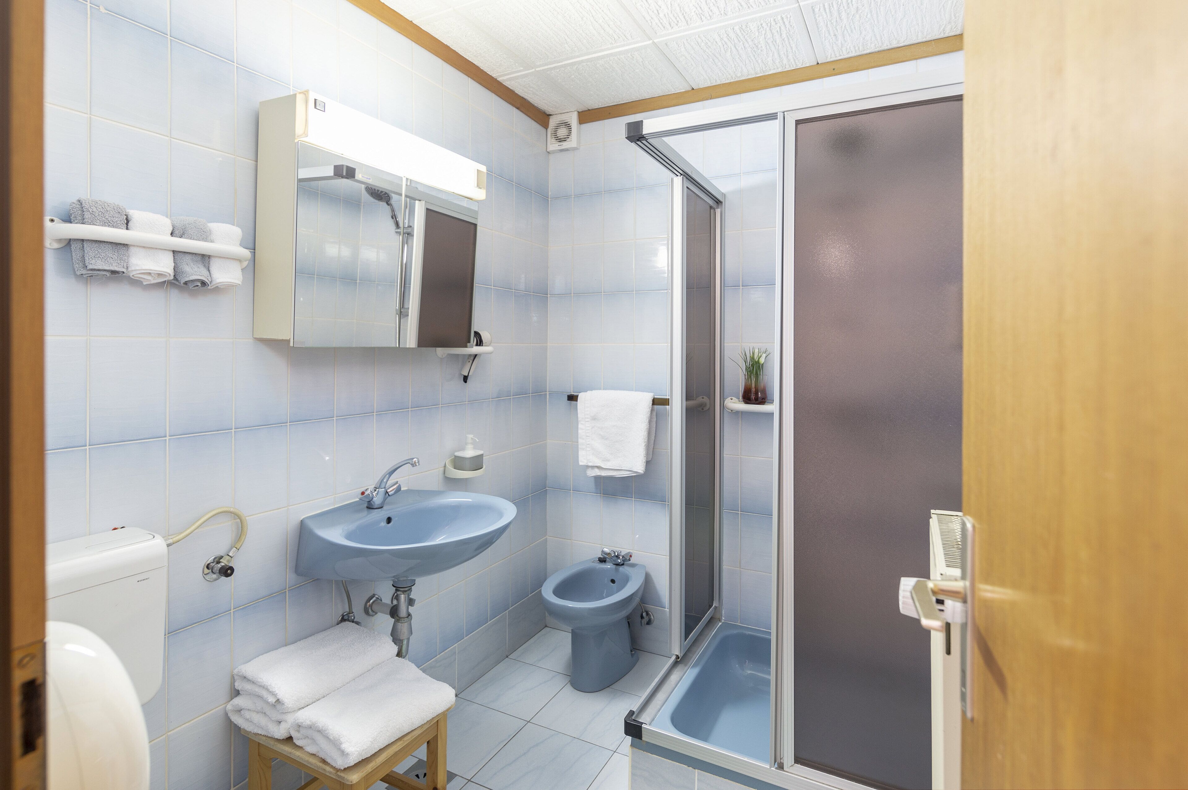 Une salle de bain équipée d’un lavabo, d’un bidet, de toilettes et d’un espace douche.