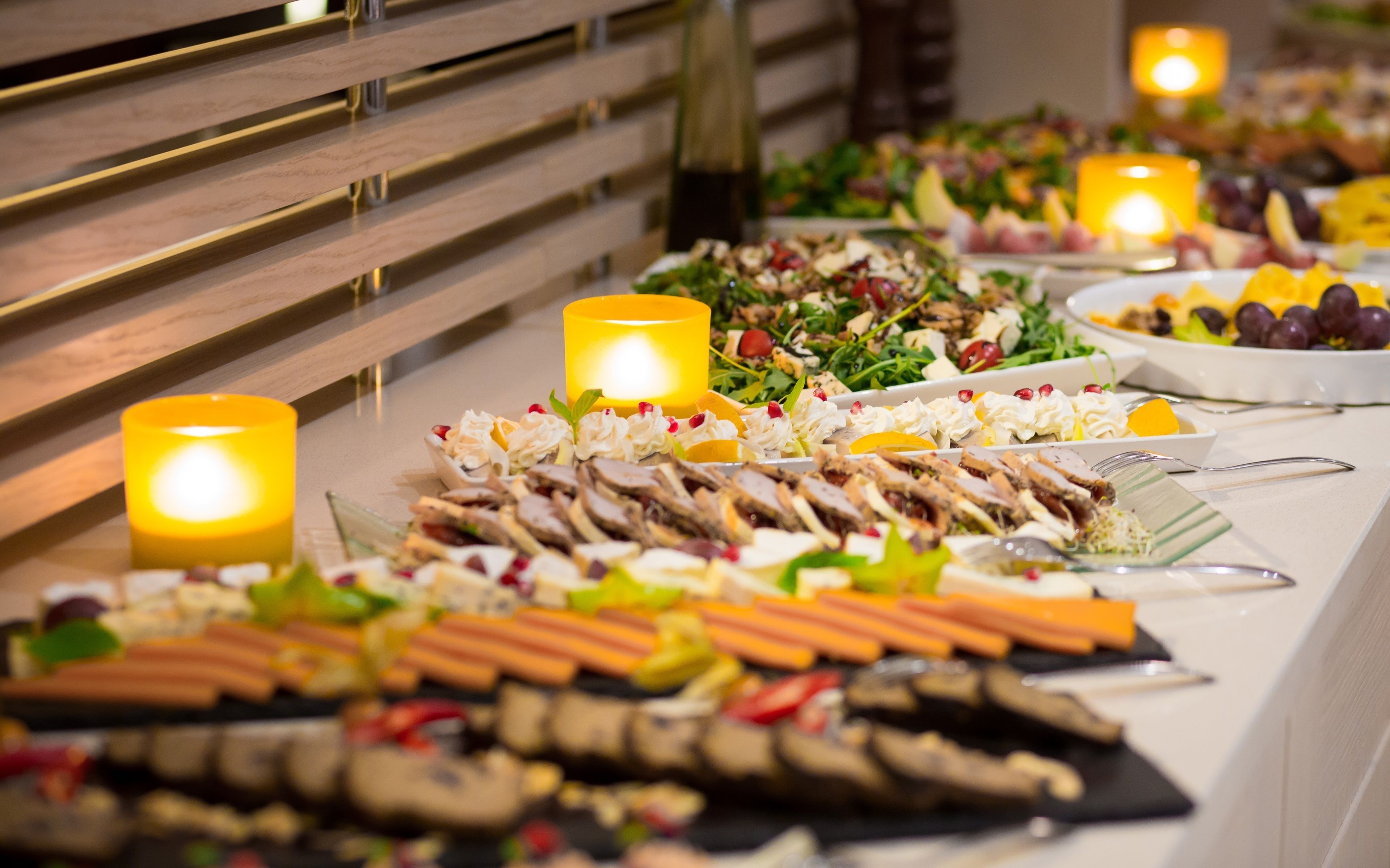 Una mesa de buffet con diversos alimentos y velas.