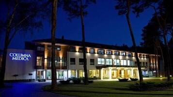 Stunning building with a flat roof and large windows, set amidst a beautifully manicured lawn and lush trees.