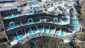 Ein Resort mit mehreren weißen Gebäuden, Schwimmbecken und einer felsigen Landschaft.