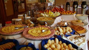Una mesa de buffet con diferentes alimentos, como pasta, pan y postres.
