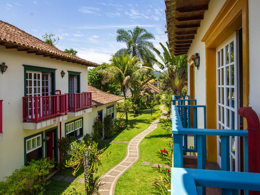 Un patio con un sendero, edificios con balcones y palmeras.