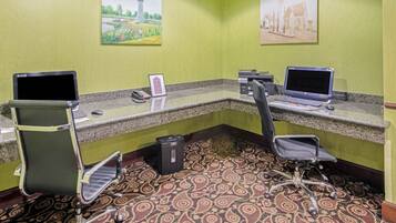 A reception area with two desks, chairs, a telephone, and a small trash bin.
