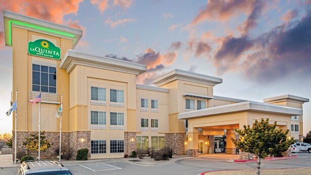 Edificio de La Quinta Inn & Suites con un diseño arquitectónico moderno, que presenta un letrero llamativo, varias ventanas y un área de estacionamiento.