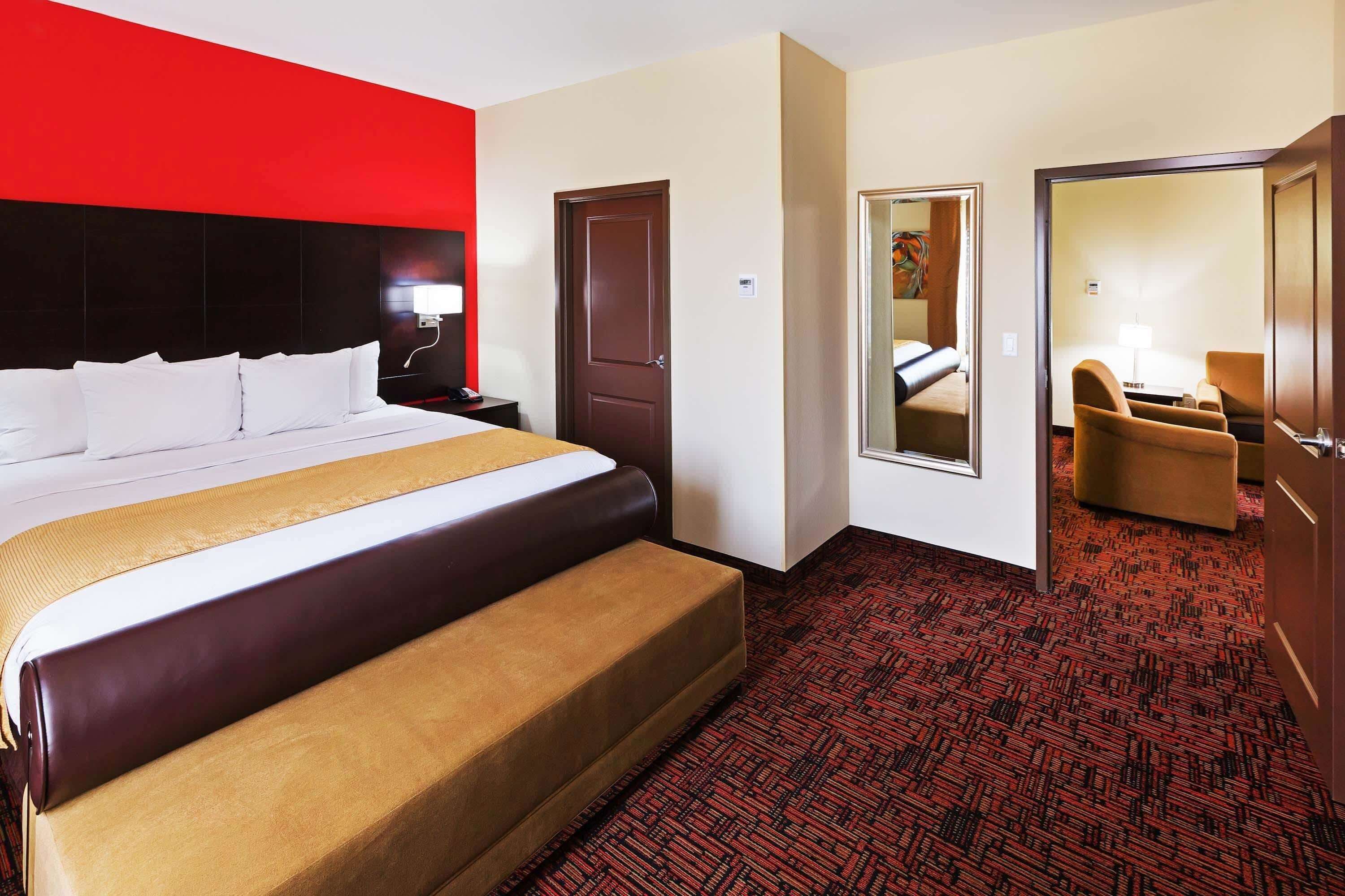 A hotel room with a large bed, a wardrobe, a desk, and a chair.