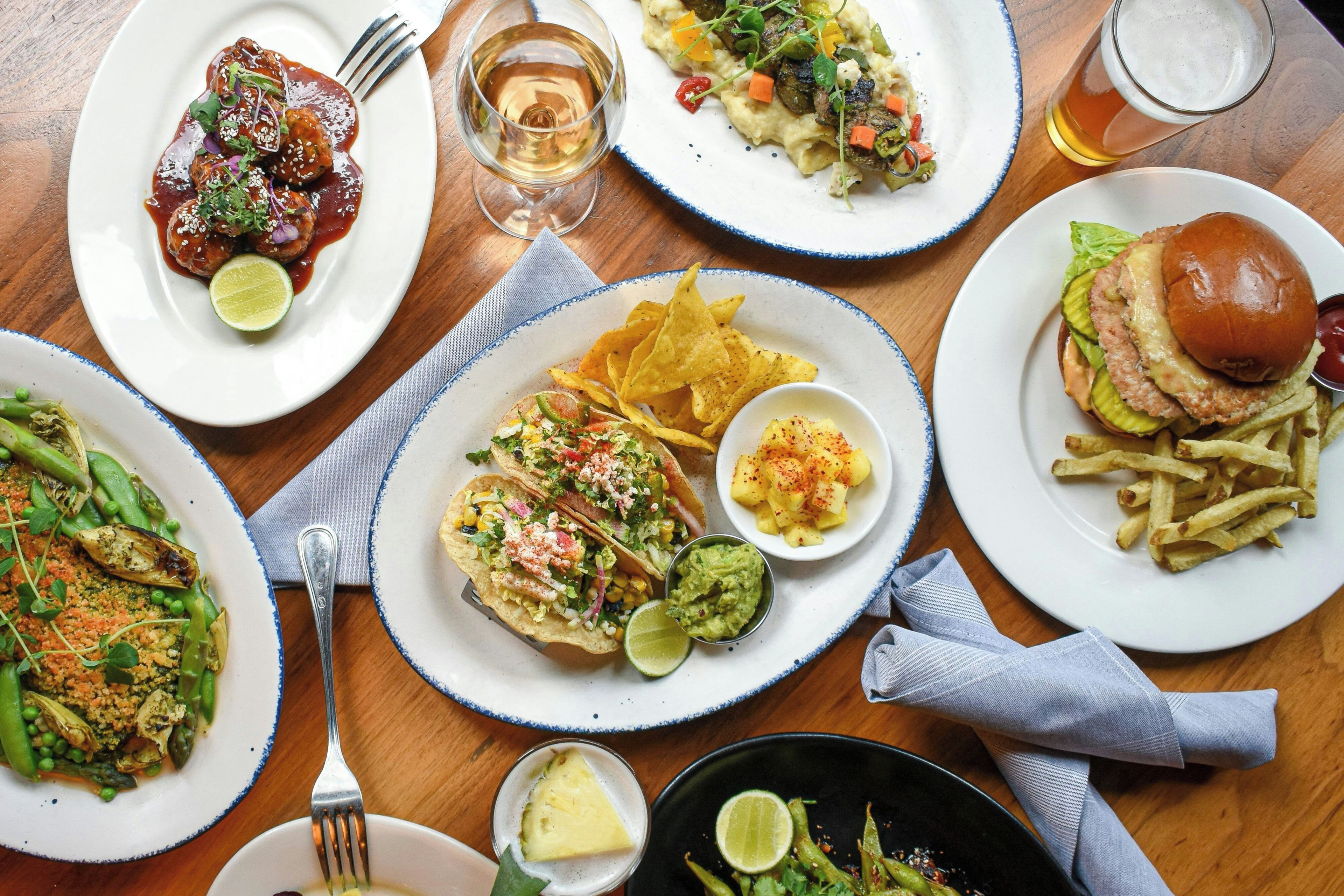 On y propose une variété de plats, notamment des tacos, un hamburger et des frites, ce qui laisse supposer un choix de repas très diversifié.