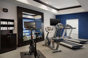 A gym with exercise equipment, a treadmill, an elliptical, and a stationary bike. - Hampton Inn Thomson (Thomson)
