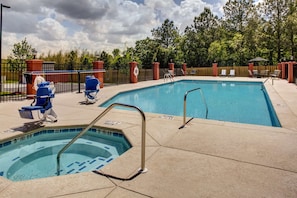 Una piscina al aire libre, sillones reclinables de piscina
