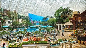 A spacious indoor area with a large pool, dining tables, and tropical plants. - InterContinental Chengdu Global Center by IHG (Chengdu)