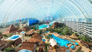 A large indoor resort with a central swimming pool, multiple levels of balconies, and a variety of resort amenities. - InterContinental Chengdu Global Center by IHG (Chengdu)