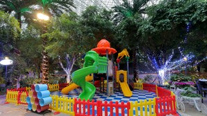A playground with slides and climbing structures, surrounded by a checkered floor and a red and yellow fence. - InterContinental Chengdu Global Center by IHG (Chengdu)