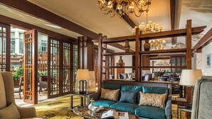 A spacious living area with a teal sofa, wooden shelving, and a chandelier. - InterContinental Chengdu Global Center by IHG (Chengdu)