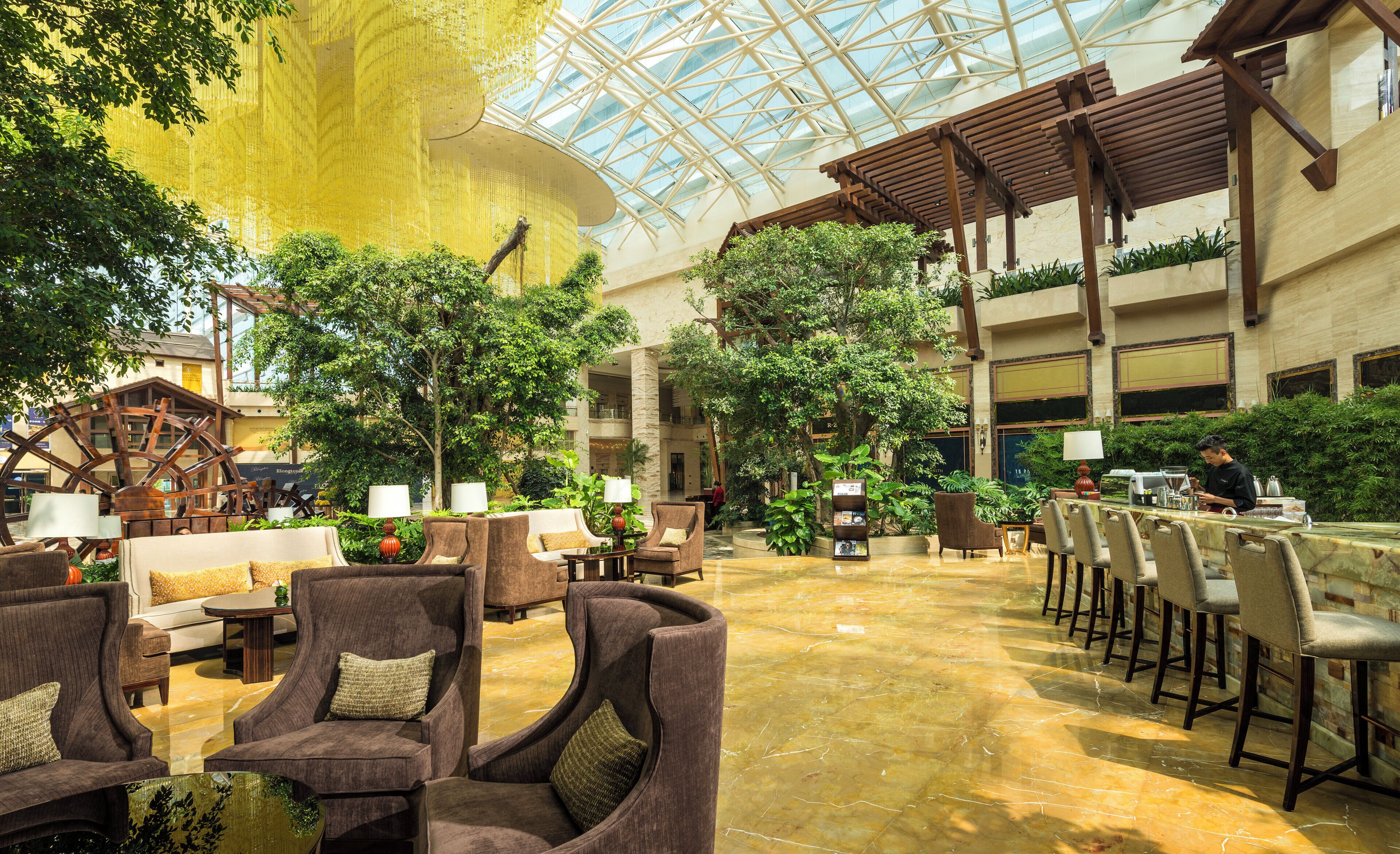 A spacious indoor area with multiple seating arrangements, including sofas and chairs, and a large water wheel structure.