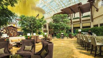 A spacious indoor area with multiple seating arrangements, including sofas and chairs, and a large water wheel structure.