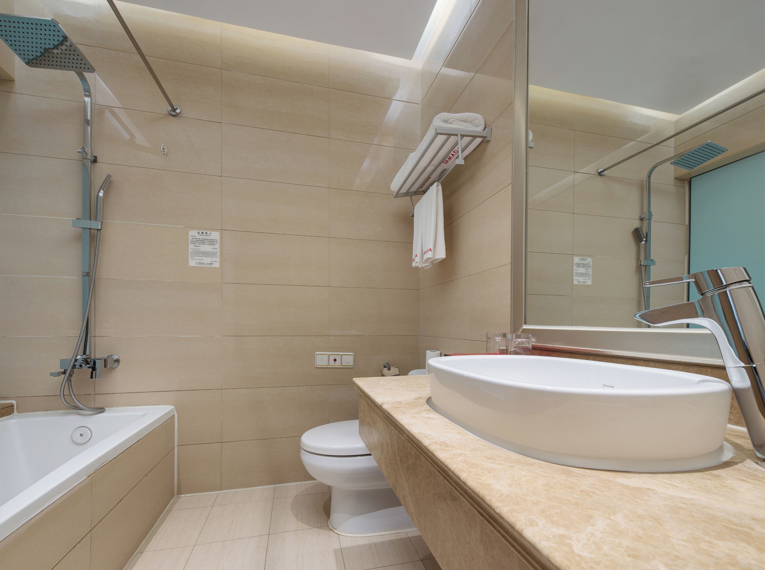 A modern bathroom with a bathtub, a toilet, and a large sink.