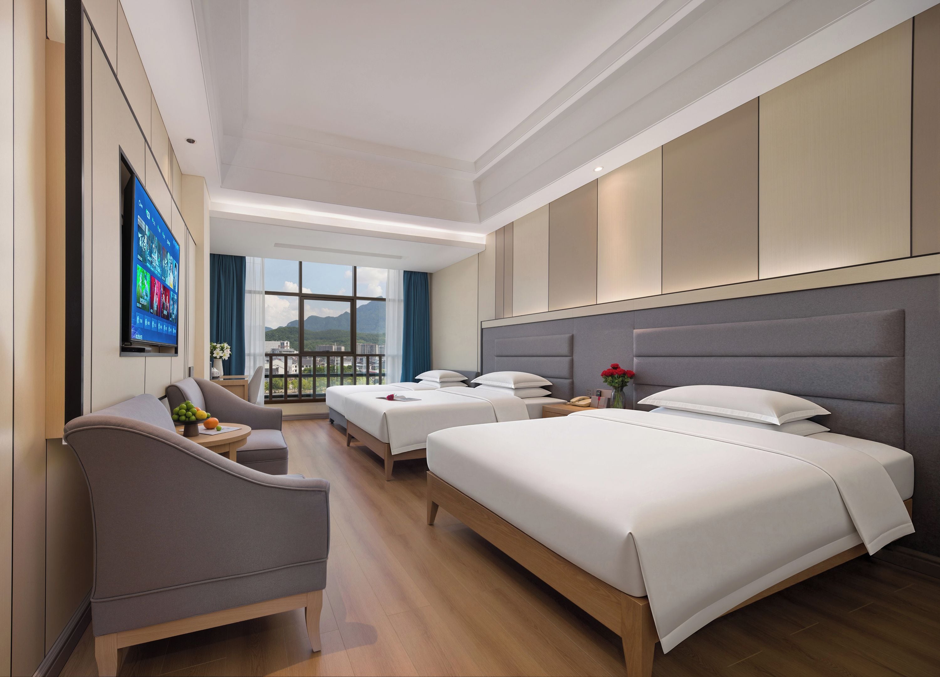 A hotel room with a large bed, a smaller bed, a sofa, a TV, and a view of the outdoors.