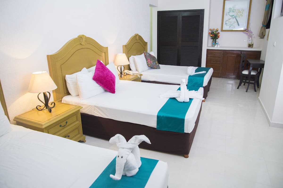 Habitación de hotel con dos camas, un escritorio y una silla.
