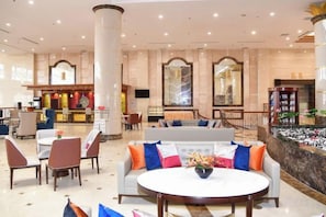 A hotel lobby with a reception desk, seating area, and a decorative fountain. - Nanshan International Conference Center Hotel (Yantai)