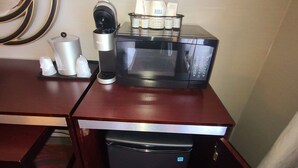 Une petite cuisine équipée d’un four à micro-ondes, d’une bouilloire et d’un petit réfrigérateur.