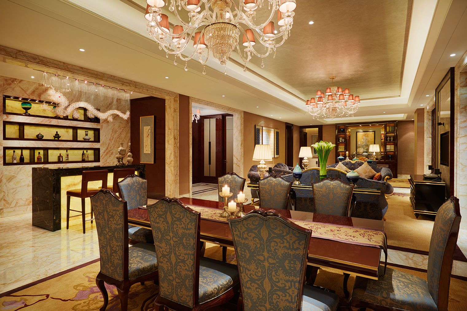 A luxurious dining area with ornate chandeliers, a marble reception desk, and a well-appointed seating arrangement.