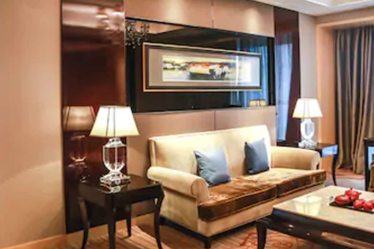 Ein modernes Hotelzimmer mit einer Couch, einem Couchtisch und einem gerahmten Bild an der Wand.