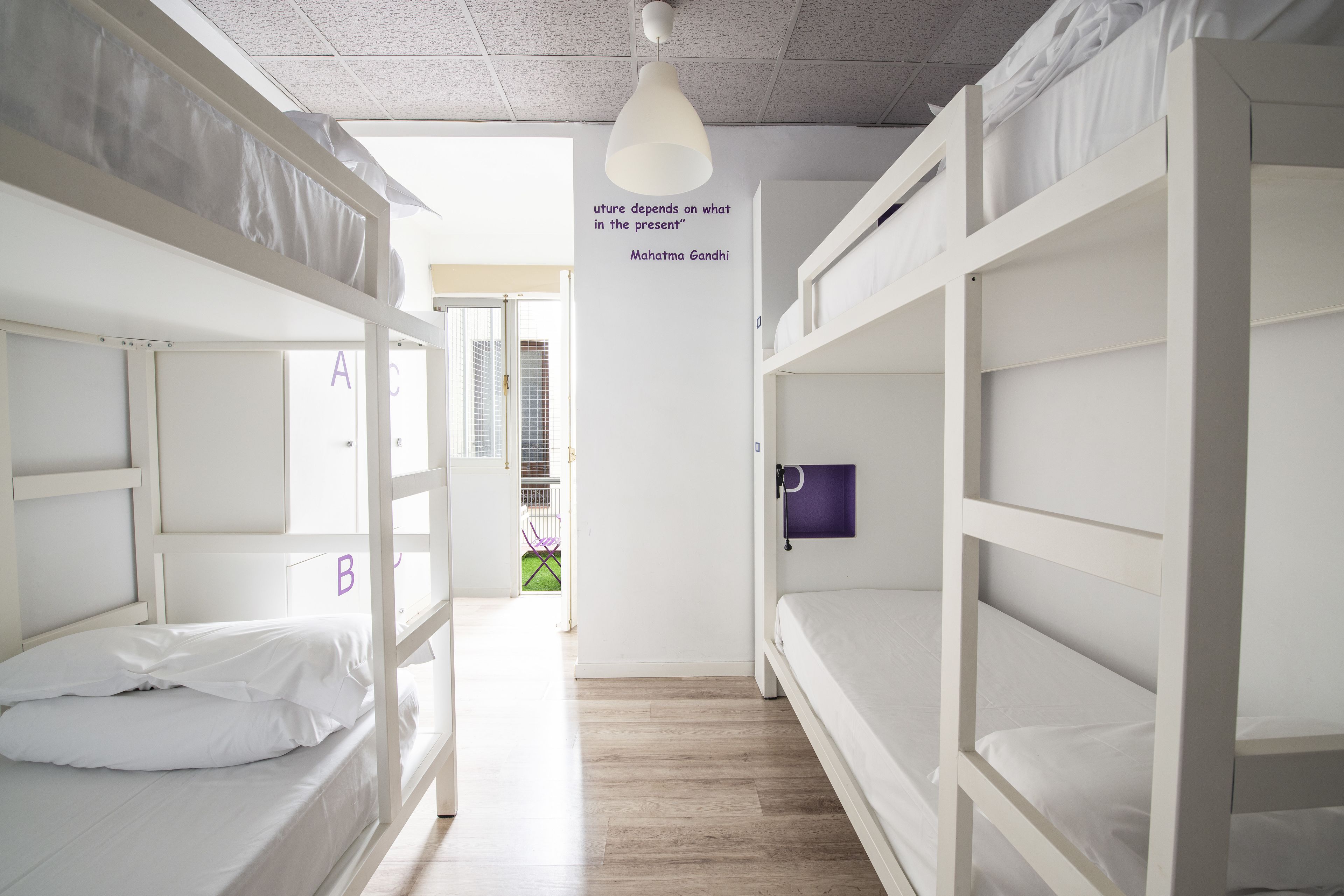 Una camera del dormitorio con letti a castello, una citazione sulla parete e una porta con l'indicazione 'A'.