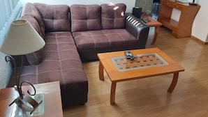 A living room with a brown leather sofa, a wooden coffee table, and a lamp. - Steinhaus Homero (Mexico City)