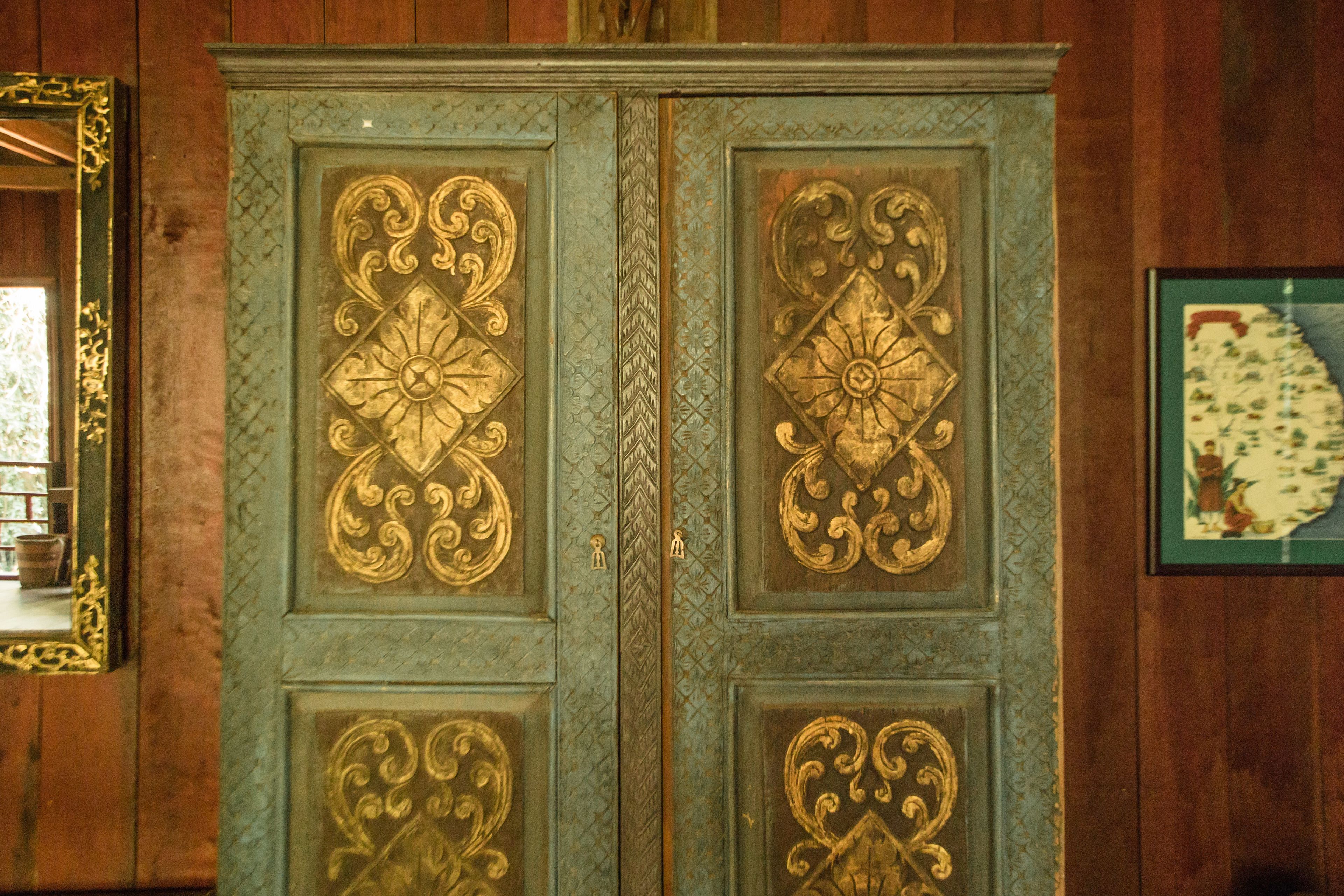 A wooden door with intricate gold designs.