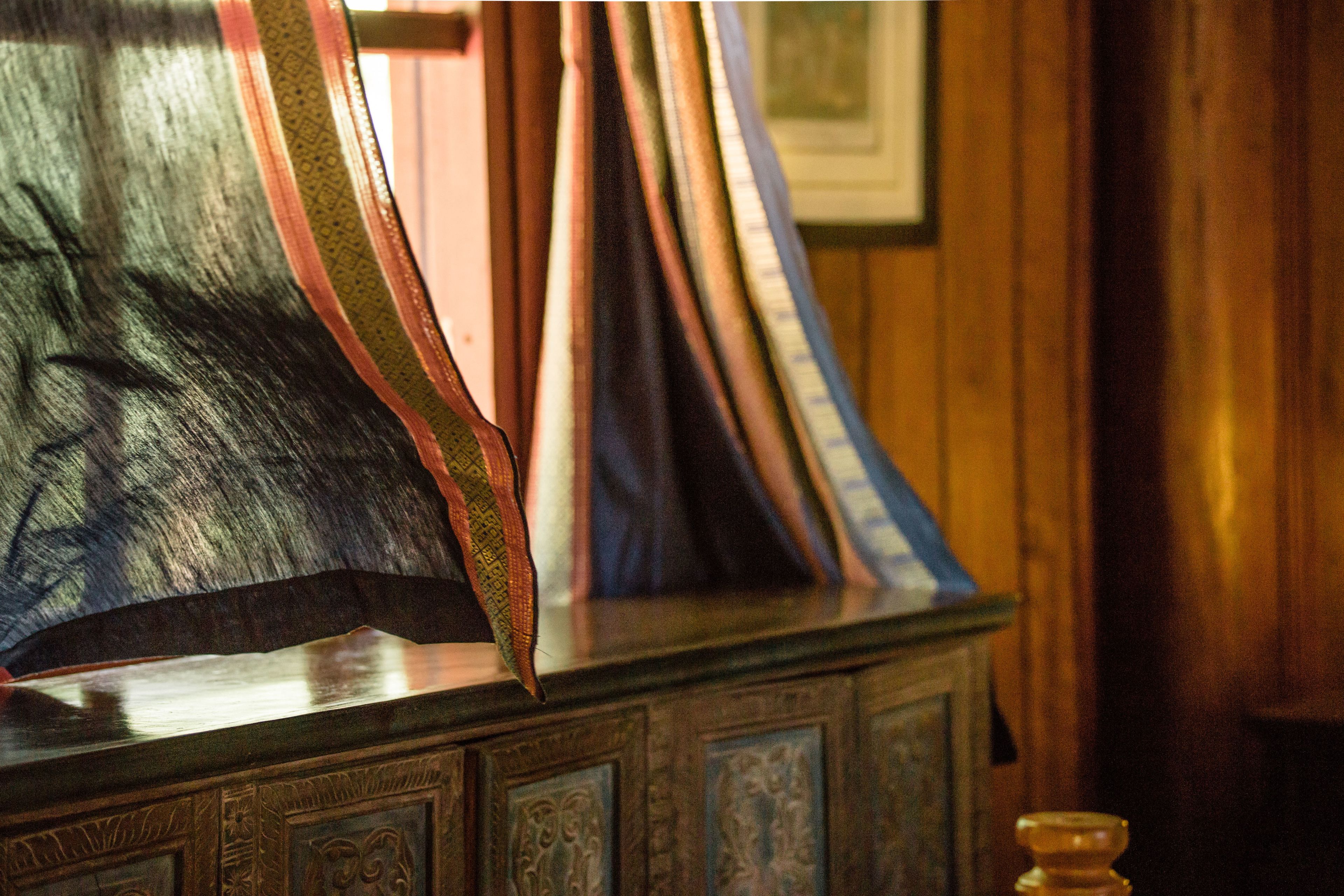 A wooden cabinet with intricate carvings and a glass display case.