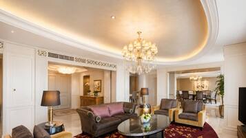 A spacious living room with a round coffee table, sofas, and a chandelier.
