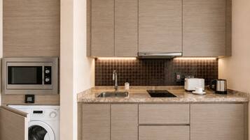 A modern kitchen with built-in appliances, a sink, and a microwave.