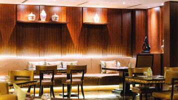 A restaurant with wooden paneling, cushioned seating, and tables set for dining.