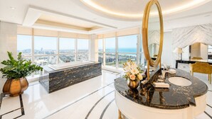 Un baño lujoso con un espejo grande, encimeras de mármol y vistas a la ciudad.