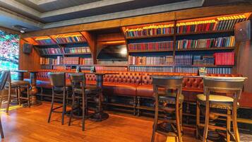 A library with bookshelves, leather seating, and wooden flooring.