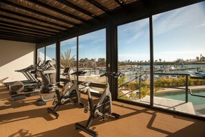 A gym with exercise equipment and a view of a marina with boats.