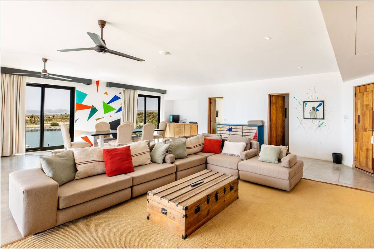 A spacious living room with a large sectional sofa, a wooden coffee table, and a ceiling fan.