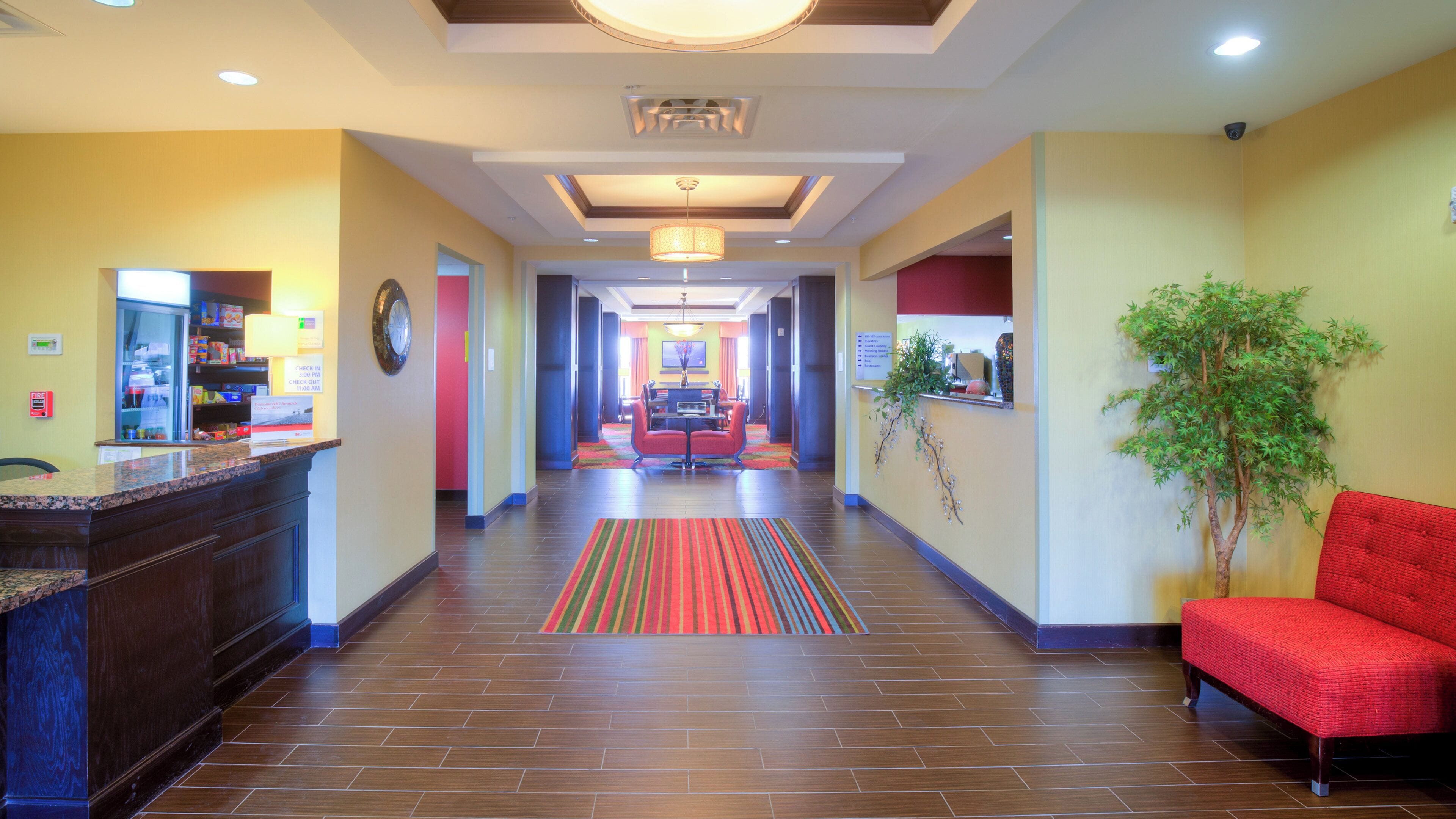 Un vestíbulo de hotel con una mesa de recepción, un comedor y un sofá rojo.