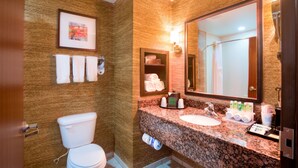 A bathroom with a toilet, sink, and large mirror. There are towels and toiletries on the counter. - Holiday Inn Express Hotel & Suites Elk City by IHG (Elk City)
