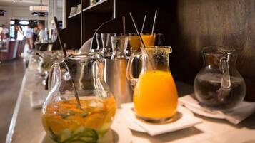 A bar area with various glasses and pitchers of beverages, including orange juice and iced tea.