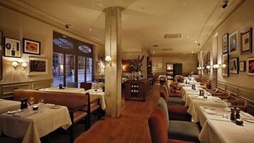 Un restaurante con mesas largas, cabinas y una columna central.