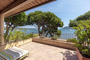 A terrace with a view of the sea, a bed, and potted plants. - Casa Santini x Roc Seven (Porto-Vecchio)