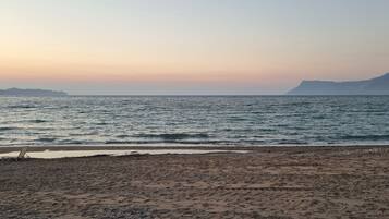 Ein Strand mit einem Liegestuhl und einer felsigen Küste.